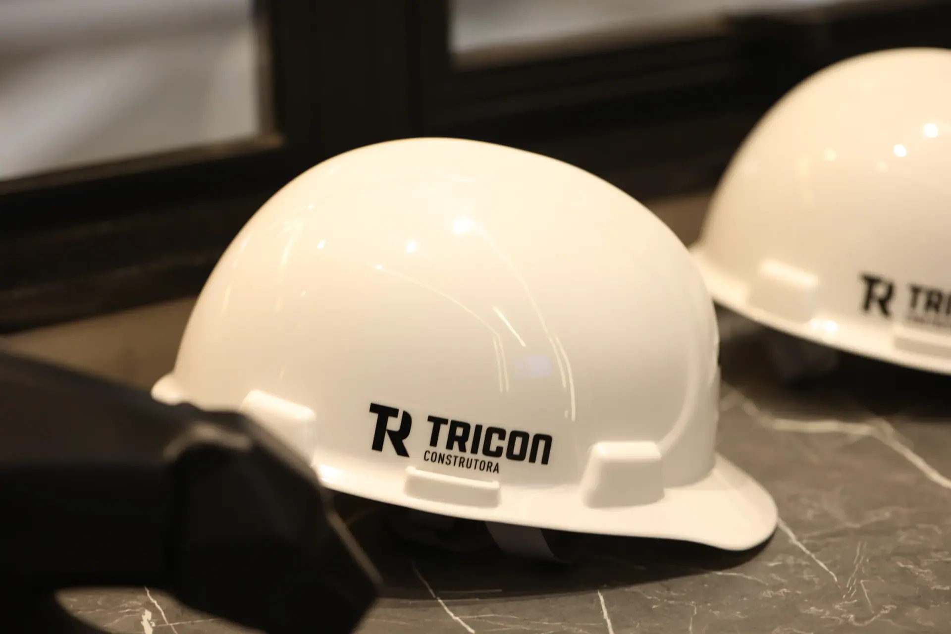 Capacetes brancos com a marca Tricon